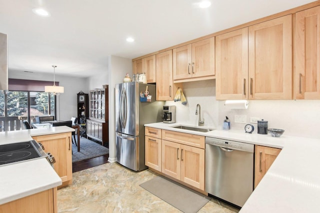 kitchen featuring light brown cabinetry, sink, decorative light fixtures, and appliances with stainless steel finishes