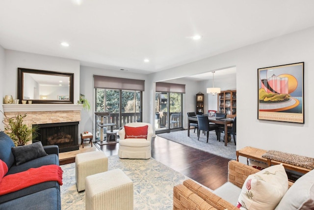 living room with a stone fireplace and hardwood / wood-style floors