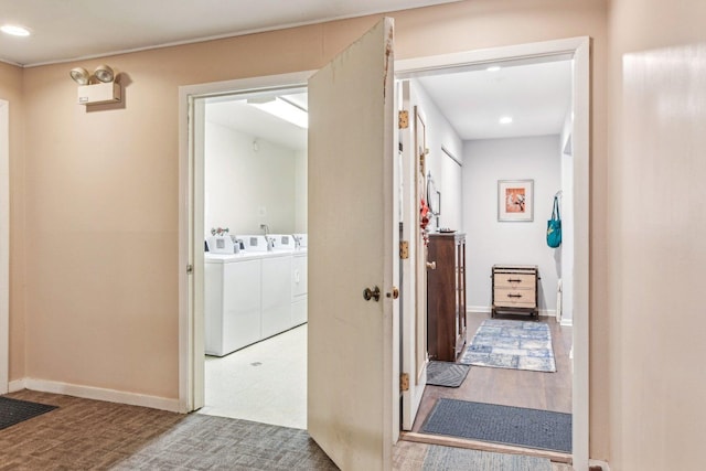 hall with hardwood / wood-style flooring and separate washer and dryer