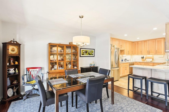 dining area with hardwood / wood-style flooring and a notable chandelier