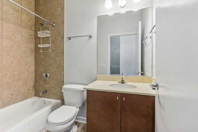 full bathroom with tiled shower / bath, vanity, and toilet