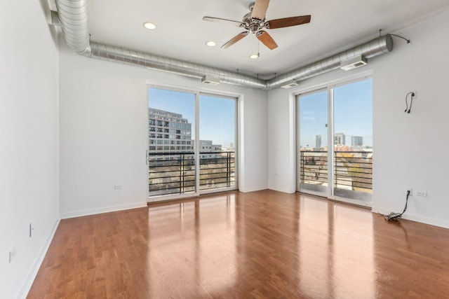 spare room with plenty of natural light, hardwood / wood-style floors, and ceiling fan