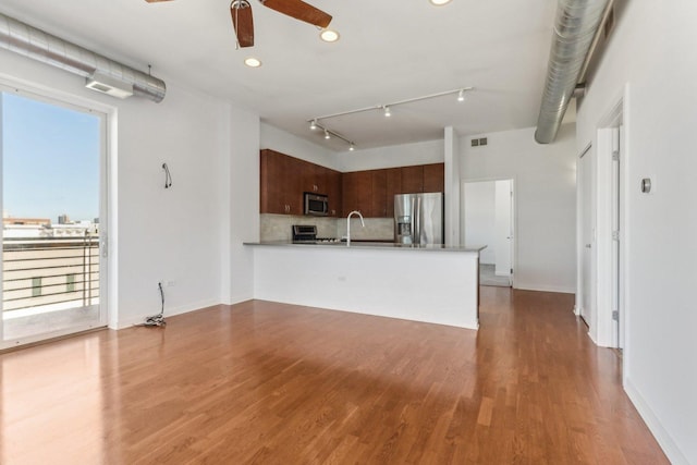 kitchen featuring sink, kitchen peninsula, hardwood / wood-style flooring, ceiling fan, and stainless steel appliances