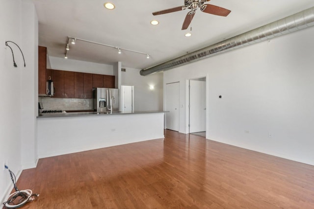 unfurnished living room featuring wood-type flooring, rail lighting, and ceiling fan