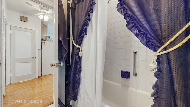 bathroom featuring hardwood / wood-style flooring and shower / bathtub combination with curtain