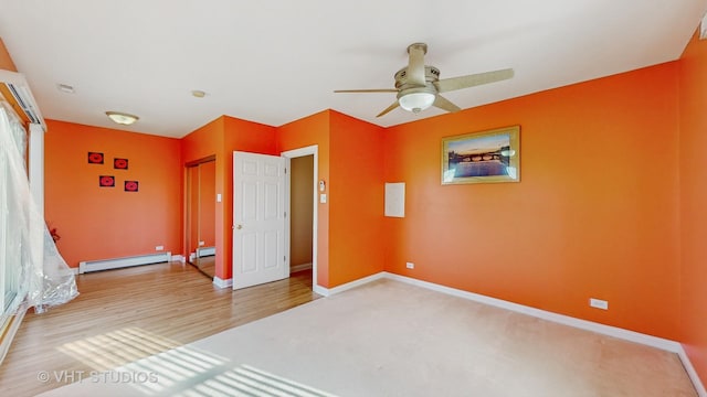 unfurnished bedroom with hardwood / wood-style flooring, a baseboard radiator, and ceiling fan