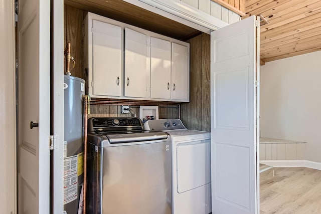 clothes washing area with light hardwood / wood-style flooring, water heater, independent washer and dryer, cabinets, and wooden ceiling