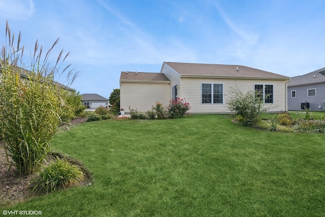 back of house with a lawn