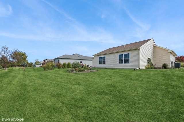 rear view of house featuring a yard and central AC