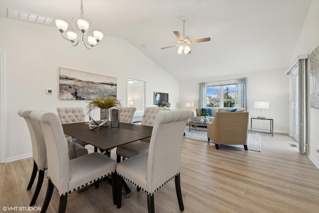 dining space featuring high vaulted ceiling, ceiling fan with notable chandelier, and light hardwood / wood-style floors