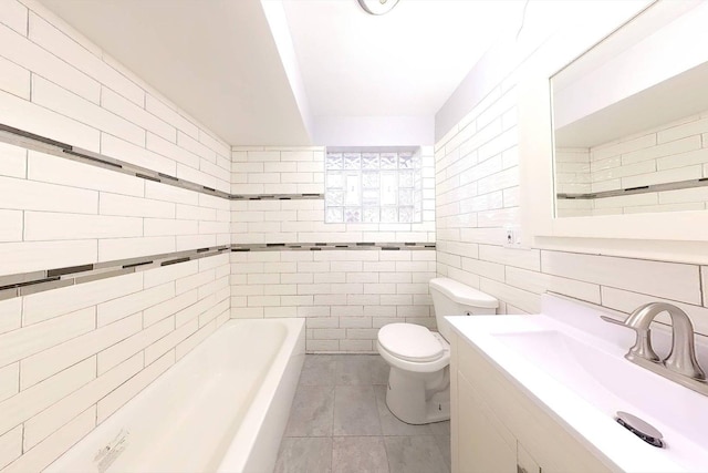 bathroom with tile patterned floors, toilet, tile walls, vanity, and a tub