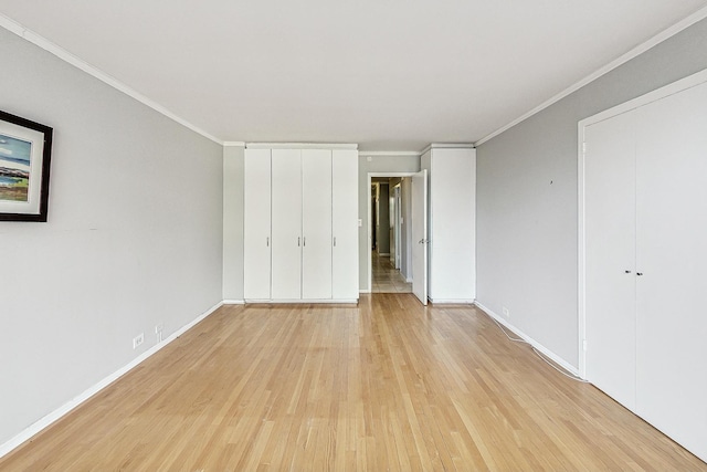 unfurnished bedroom featuring crown molding and light wood-type flooring