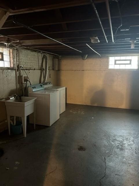 basement featuring separate washer and dryer, sink, and a wealth of natural light