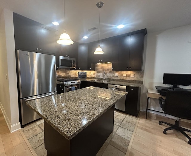 kitchen with pendant lighting, light hardwood / wood-style flooring, stainless steel appliances, a center island, and decorative backsplash