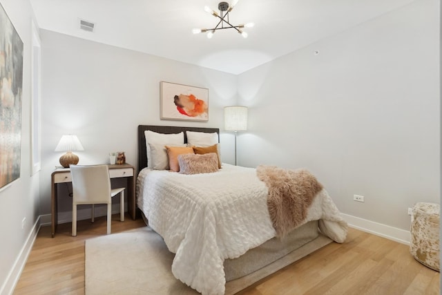 bedroom featuring a chandelier and wood-type flooring