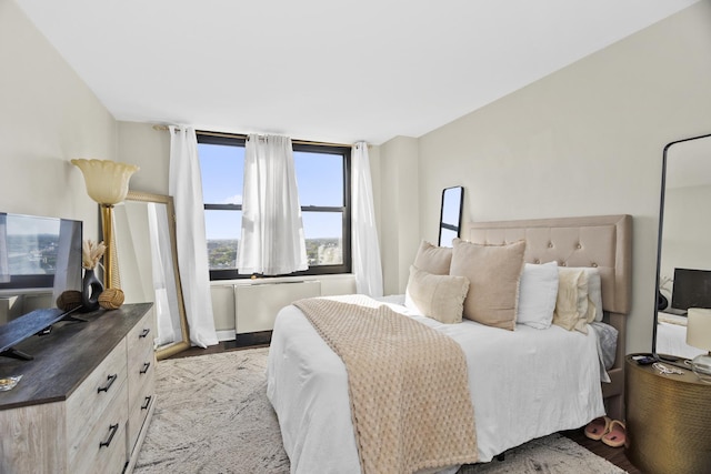 bedroom featuring radiator heating unit and light hardwood / wood-style floors