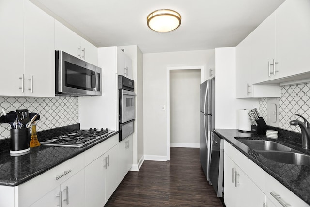 kitchen featuring stainless steel appliances, sink, white cabinets, and backsplash