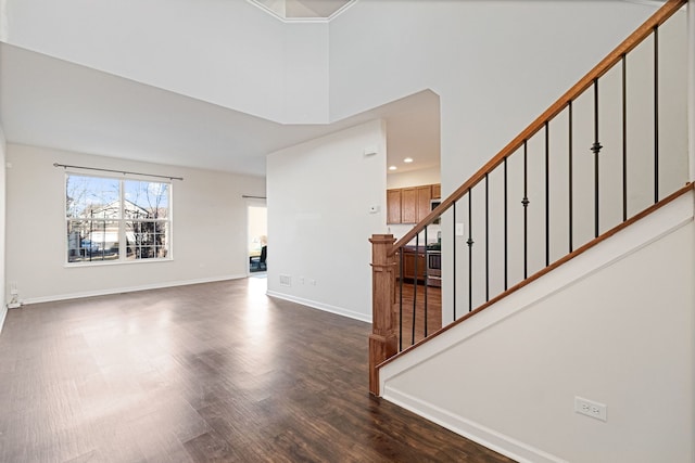 entryway with dark wood-type flooring and a towering ceiling