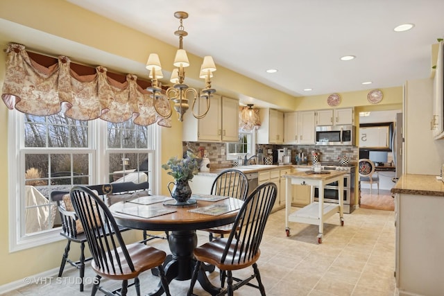 dining space with an inviting chandelier, plenty of natural light, and sink