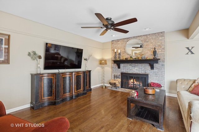 living room featuring dark hardwood / wood-style flooring, a fireplace, and ceiling fan