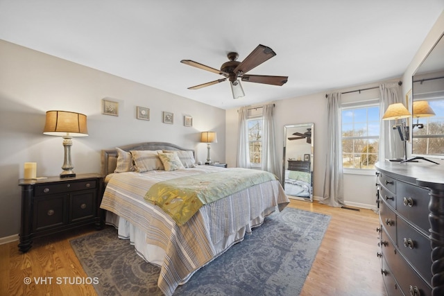 bedroom with multiple windows, light hardwood / wood-style flooring, and ceiling fan