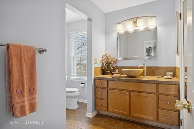 bathroom with tile patterned flooring, vanity, and toilet