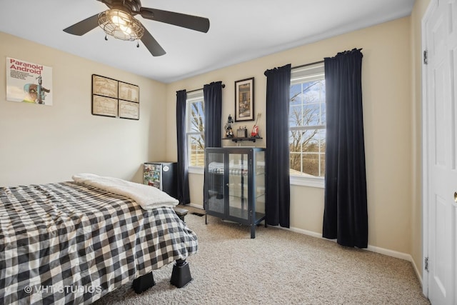 carpeted bedroom featuring multiple windows and ceiling fan