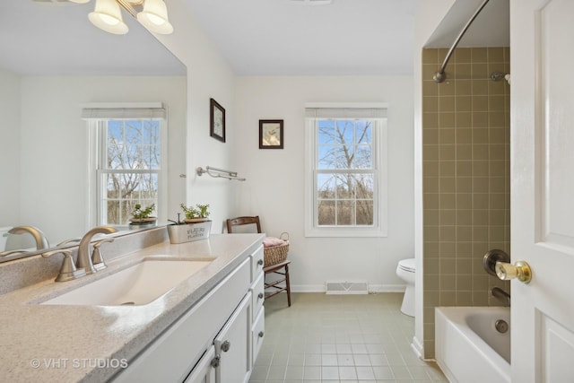 full bathroom featuring vanity, tiled shower / bath combo, plenty of natural light, and toilet