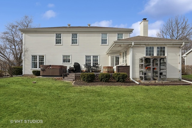 back of house featuring a hot tub, a patio, and a yard