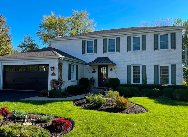 colonial home with a garage and a front lawn