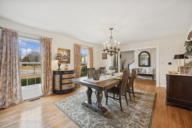 dining space featuring an inviting chandelier and light hardwood / wood-style flooring