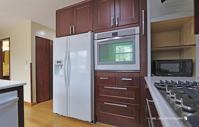 kitchen with white appliances and light hardwood / wood-style flooring