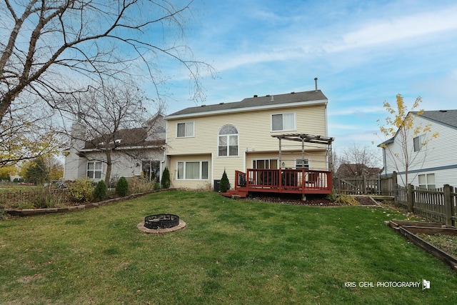 back of house with a fire pit, a yard, a pergola, and a deck