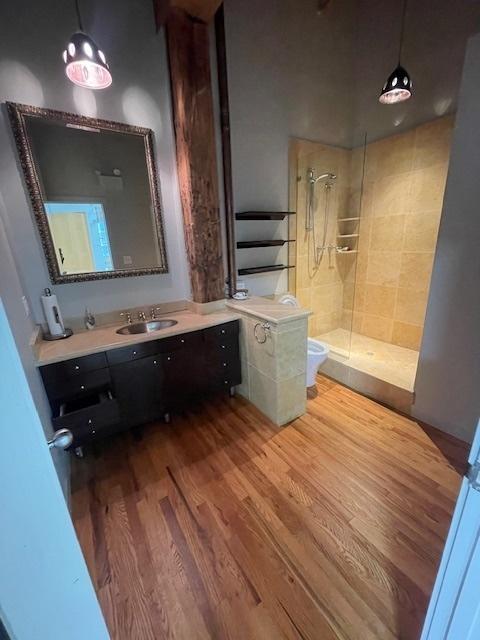 bathroom with vanity, toilet, hardwood / wood-style floors, and walk in shower