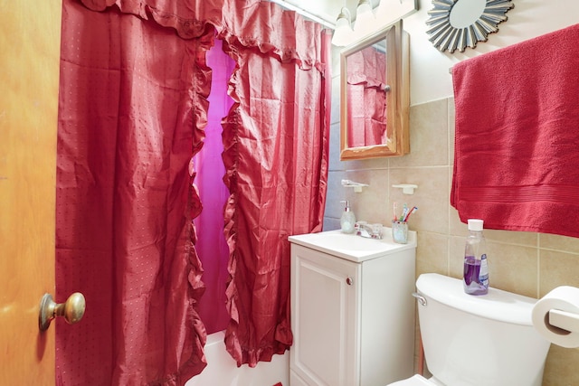 full bathroom featuring shower / tub combo with curtain, vanity, toilet, and tile walls