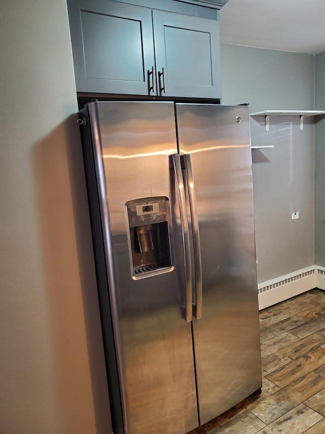 kitchen featuring a baseboard heating unit, light hardwood / wood-style floors, and stainless steel fridge with ice dispenser