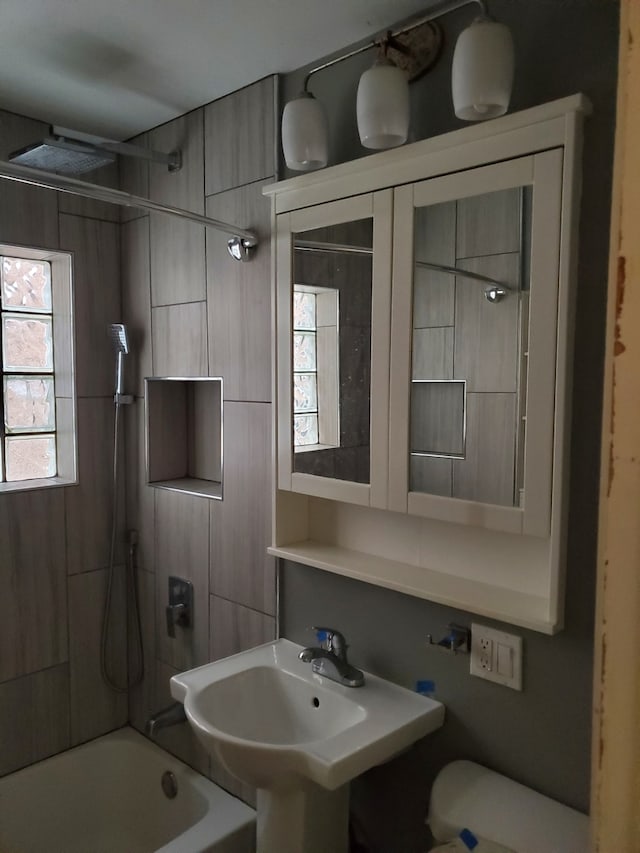 bathroom featuring tiled shower / bath and sink