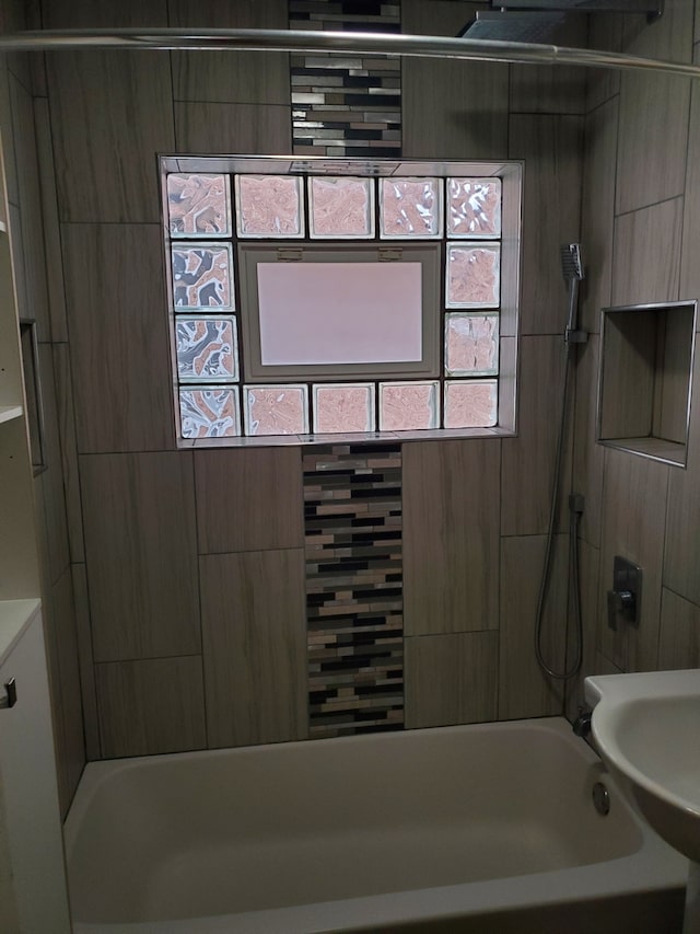 bathroom featuring sink and tiled shower / bath