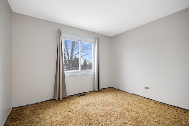 carpeted empty room featuring visible vents