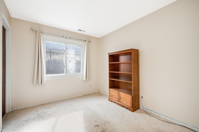 spare room featuring visible vents, light carpet, and baseboards