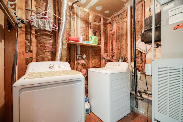 laundry room featuring brick floor, laundry area, and washer and clothes dryer