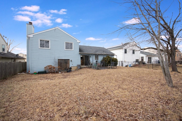 back of property featuring a chimney and a fenced backyard