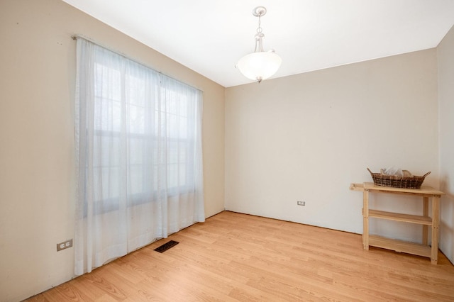 empty room featuring light wood finished floors and visible vents