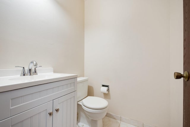 bathroom featuring toilet, tile patterned flooring, vanity, and baseboards