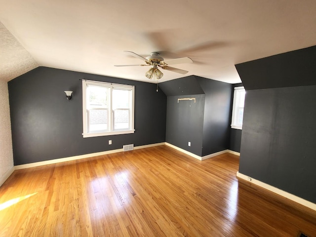 additional living space featuring ceiling fan, lofted ceiling, and light wood-type flooring