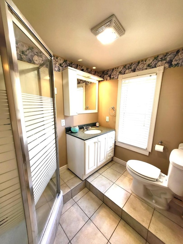 bathroom featuring vanity, a shower with shower door, tile patterned floors, and toilet