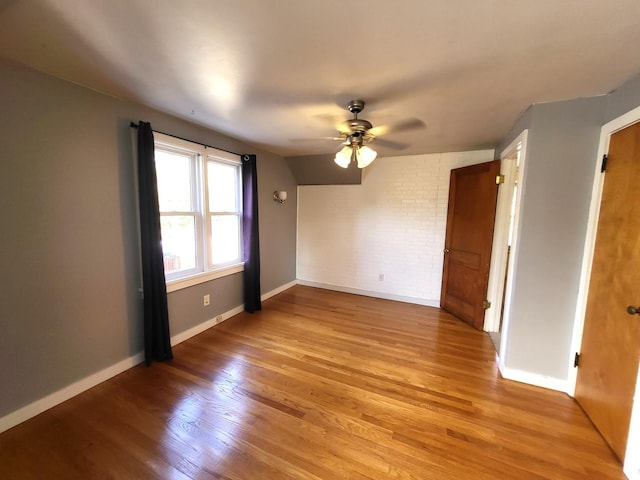 empty room featuring lofted ceiling, light hardwood / wood-style flooring, and ceiling fan