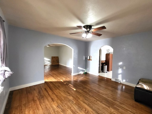 unfurnished living room featuring ceiling fan and wood-type flooring