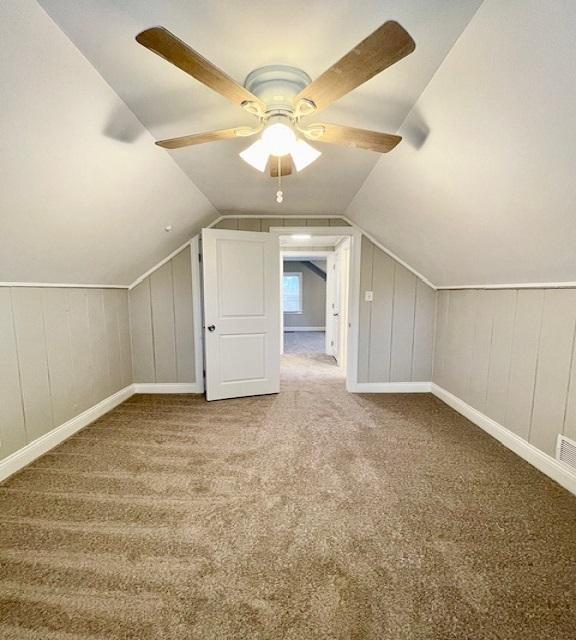 additional living space with lofted ceiling, carpet floors, and ceiling fan