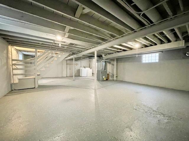 basement featuring heating unit and independent washer and dryer